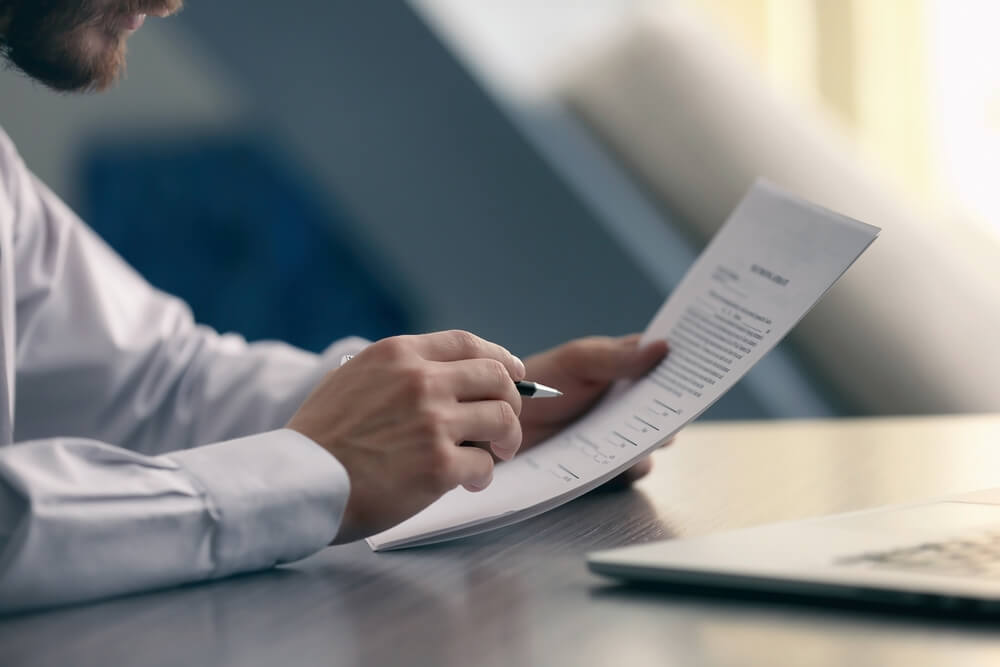 men are looking at the documents to analyze problems and find solutions before bringing the information to a meeting